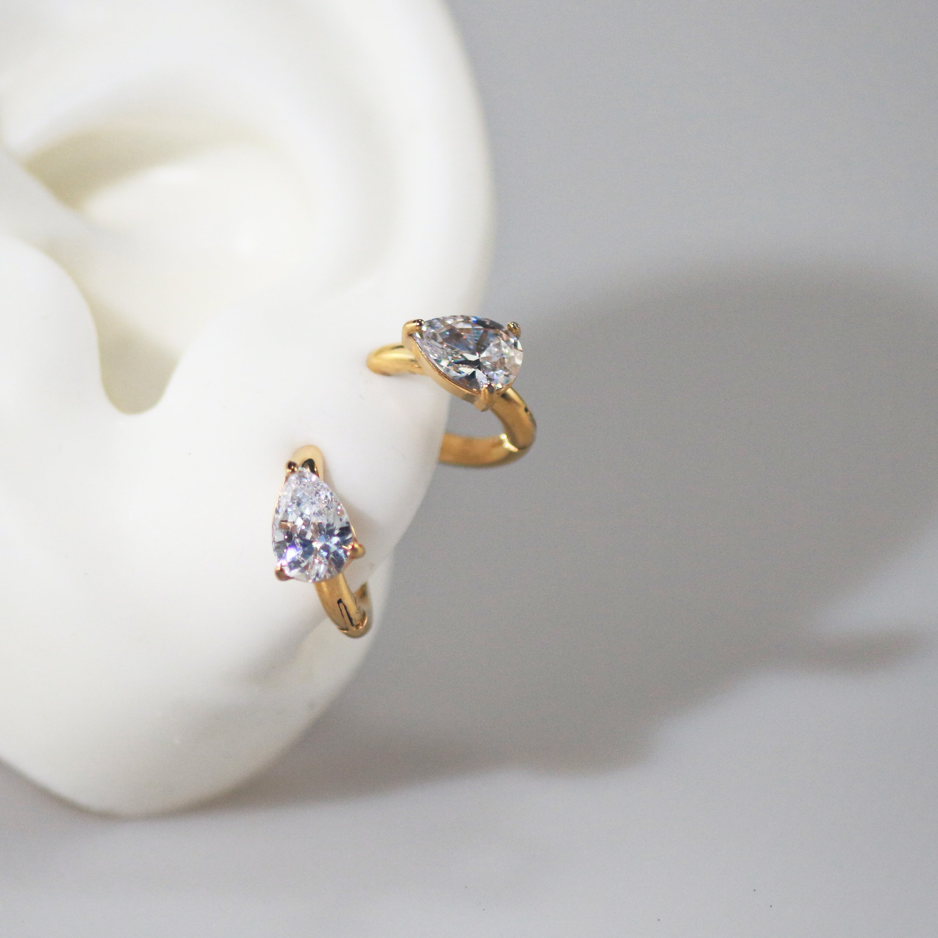 Pearla CZ Huggie Earrings | 18k Gold Plated, Pear-Shaped Gemstone 1